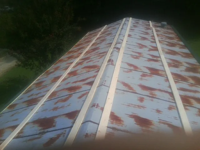 Rusted metal roof panels with new wood purlins before replacement — Storm Damage Roof Repair in Neihart by Roofing Brothers